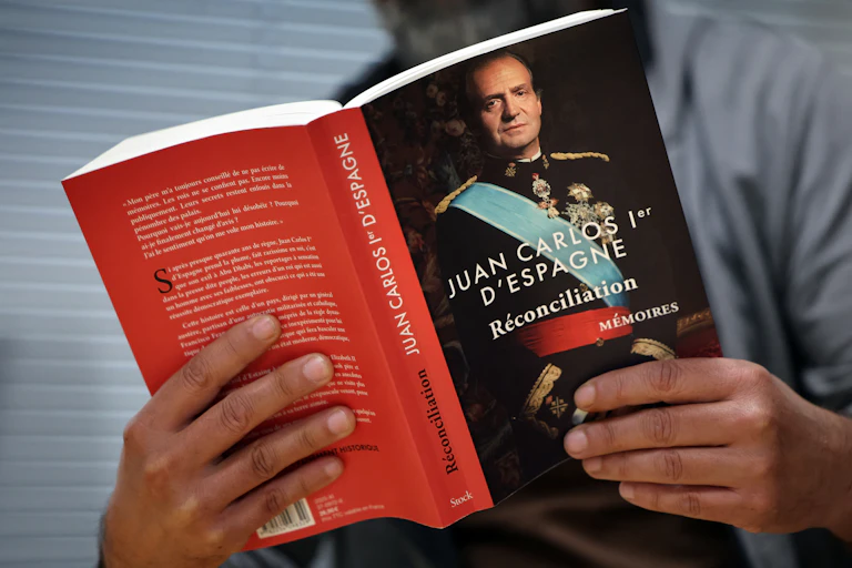 Un homme tient un livre dans ses mains.