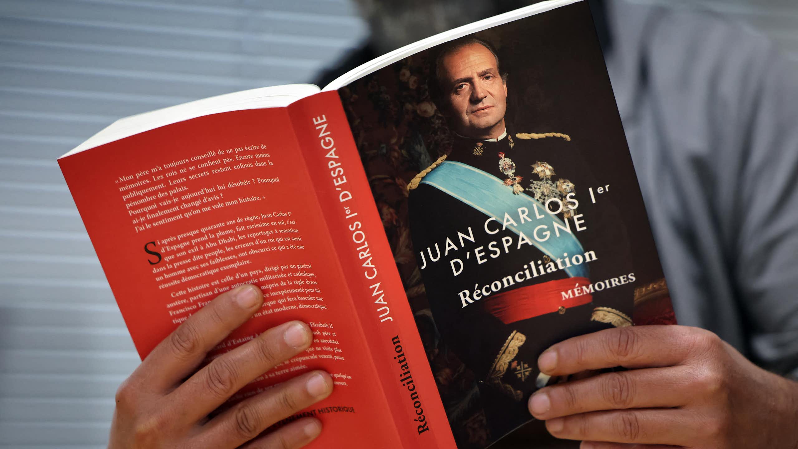 Un homme tient un livre dans ses mains.