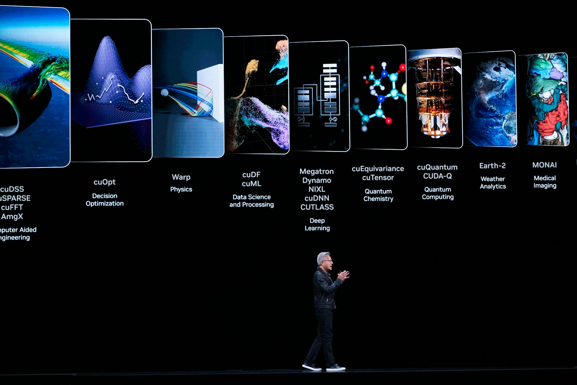 A man walks across a stage while a presentation on AI plays in the background