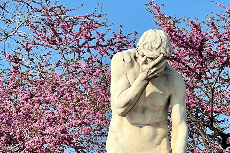 A statue holding its head in its hands