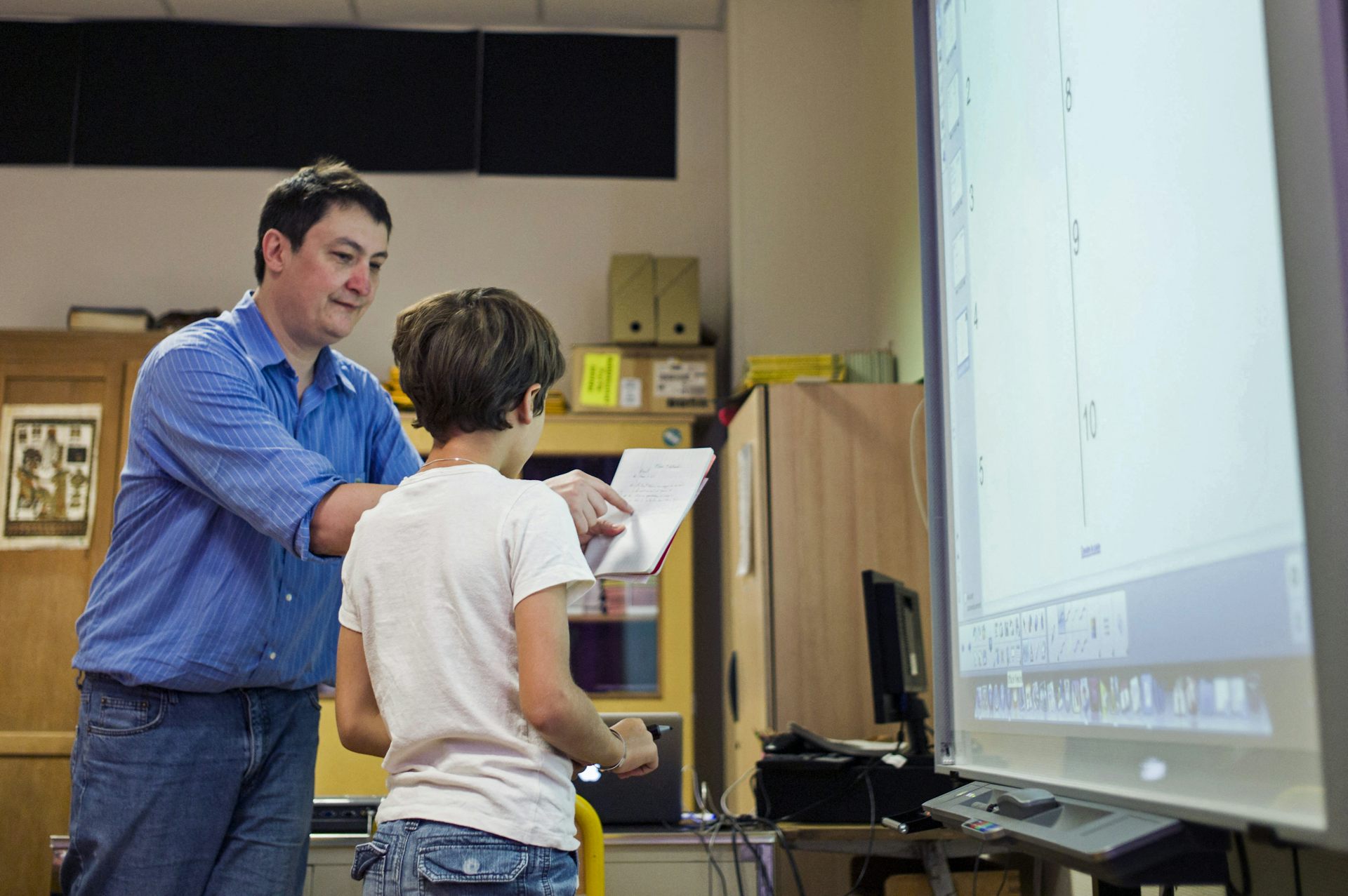 Un enseignement accompagne un élève dans sa lecture, en 2014, à Paris