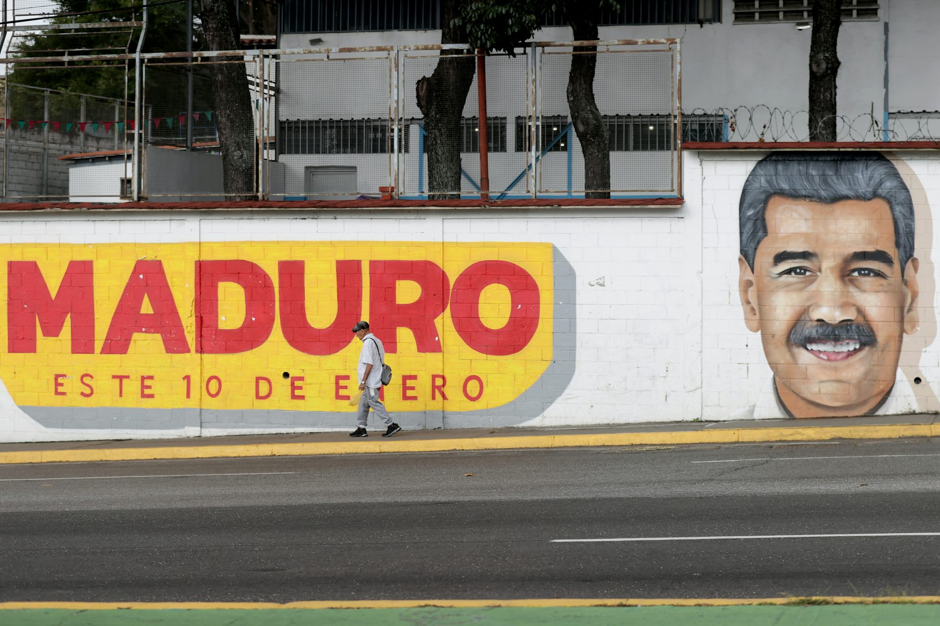 A man walks in front of a mural of Venezuelan president Nicolás Maduro in Caracas, Venezuela.