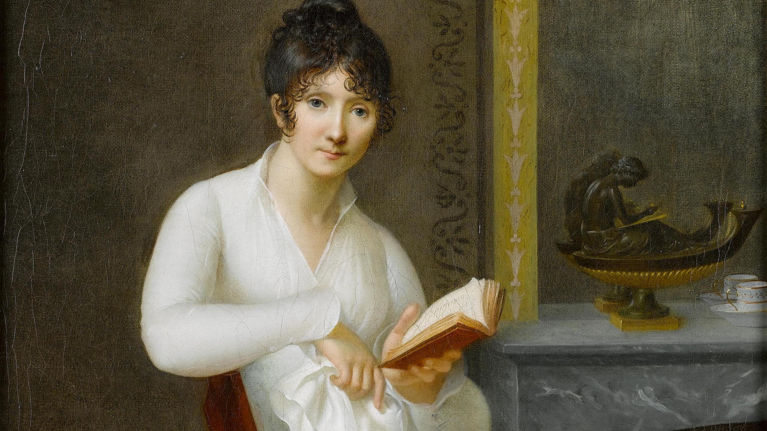 Portrait of a young lady, seated small three-quarter-length, before a fireplace, in a white dress, holding a book