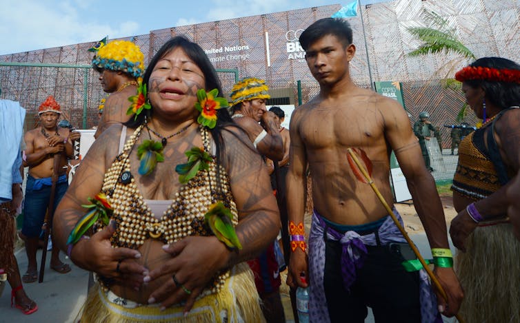 people in indigenous clothing outside cop30 building