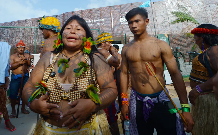 people in indigenous clothing outside cop30 building