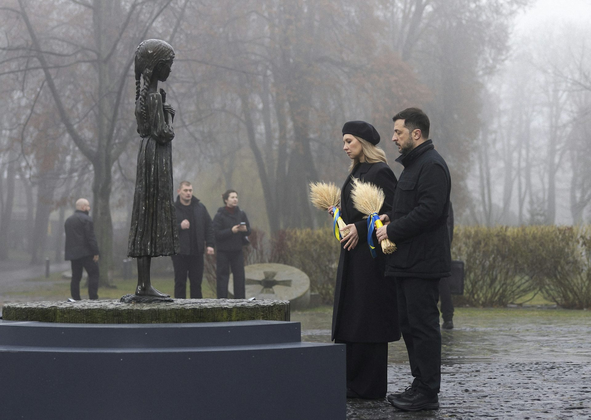 Volodymyr Zelensky and his wife Olena Zelenska place wreaths on a memorial.