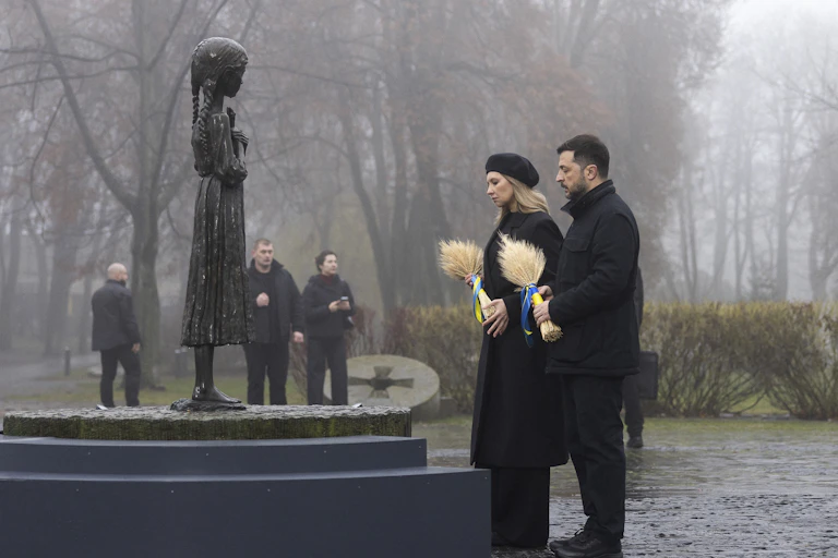 Volodymyr Zelensky and his wife Olena Zelenska place wreaths on a memorial.