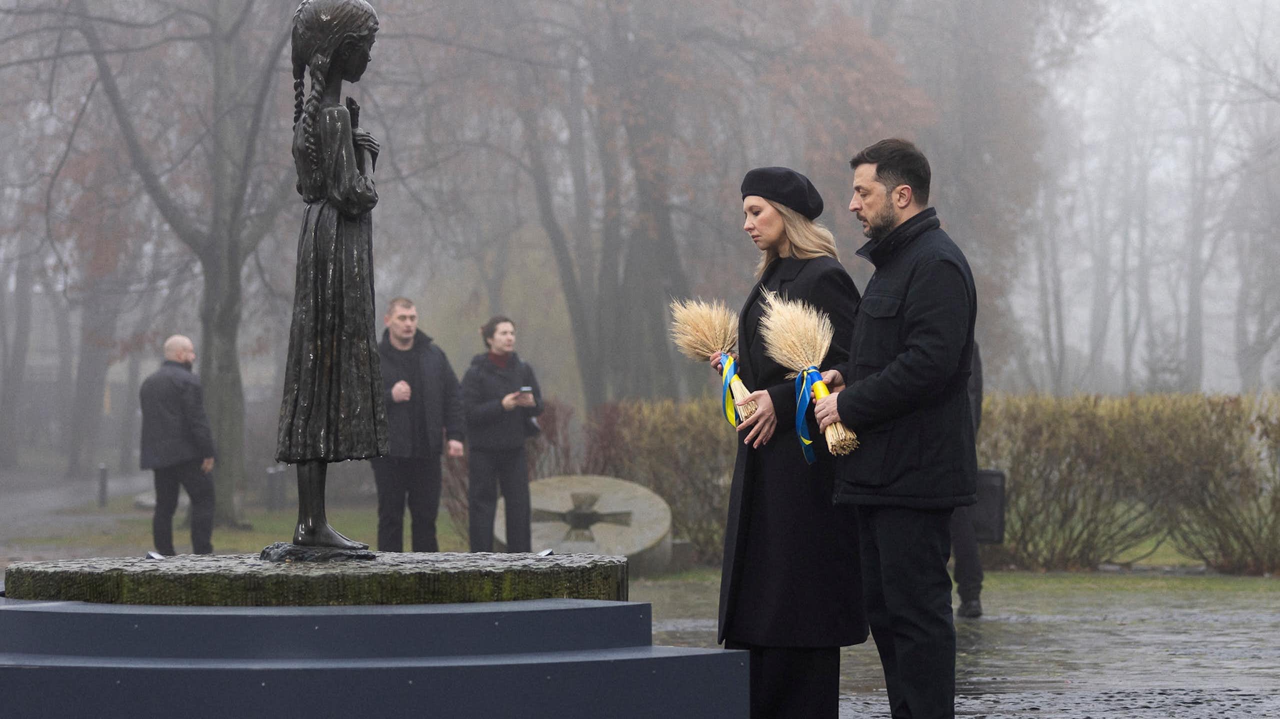 Volodymyr Zelensky and his wife Olena Zelenska place wreaths on a memorial.