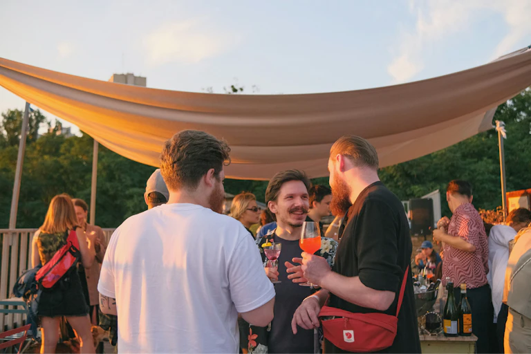 Men chat at an outdoor barbecue