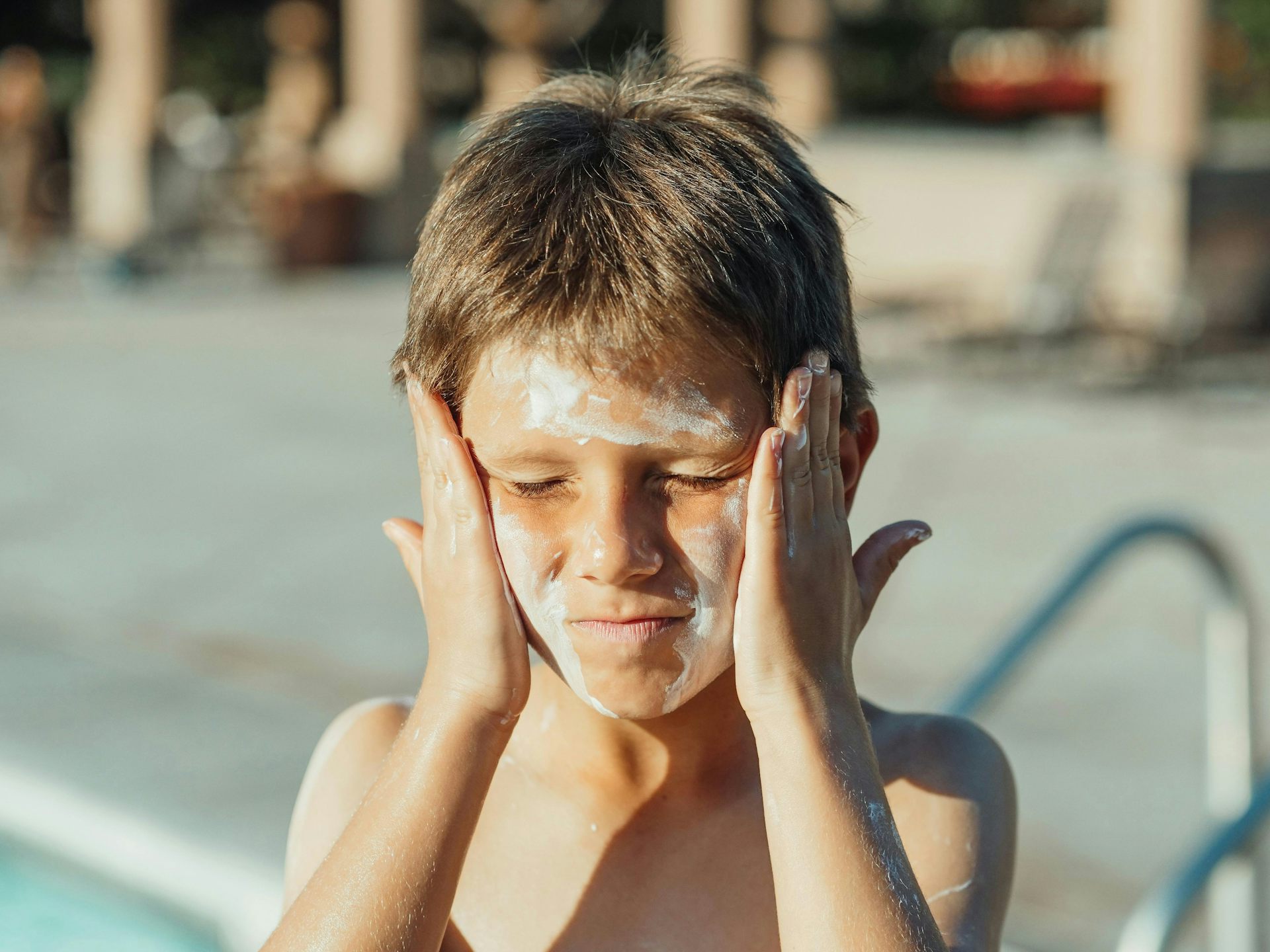A child having a bad time putting on sunscreen.