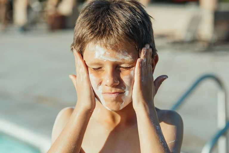 A child having a bad time putting on sunscreen.
