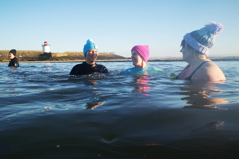 Women in woolly hats in the sea