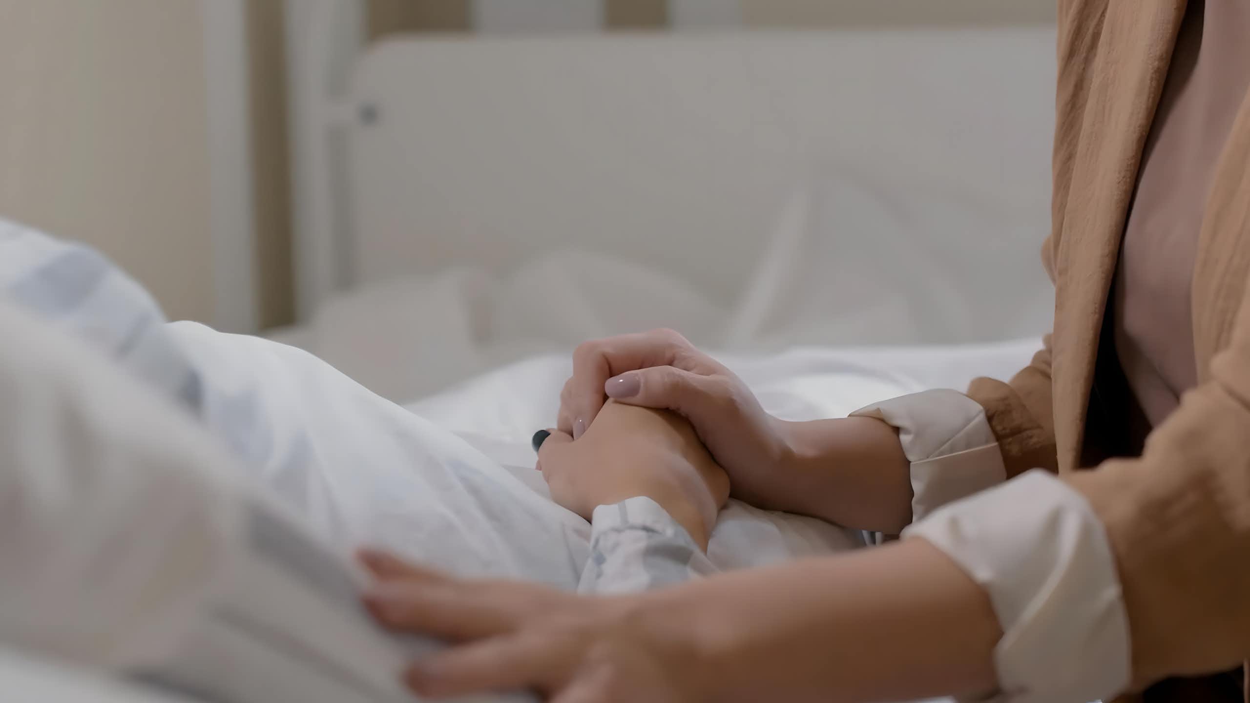 Una mano sujeta otra de un enfermo.