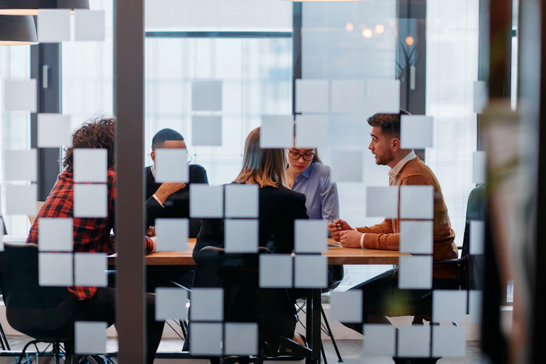 Employees are seen in a meeting room.