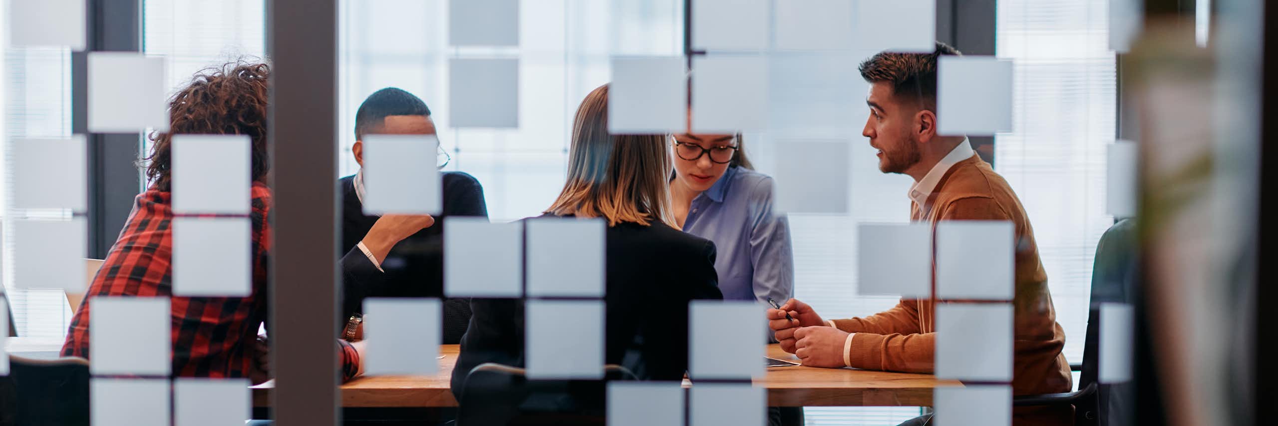 Employees are seen in a meeting room.