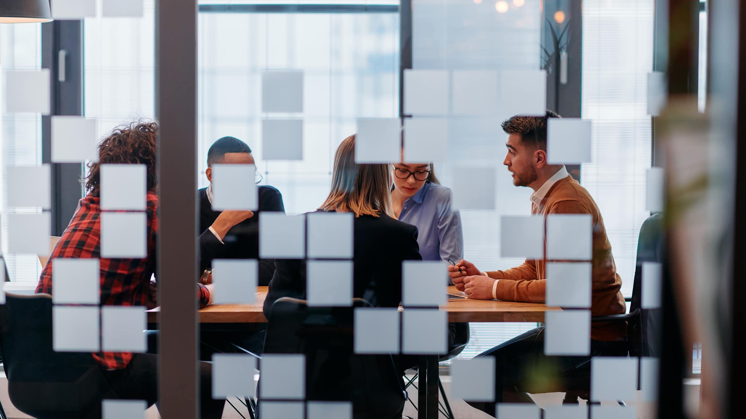 Employees are seen in a meeting room.
