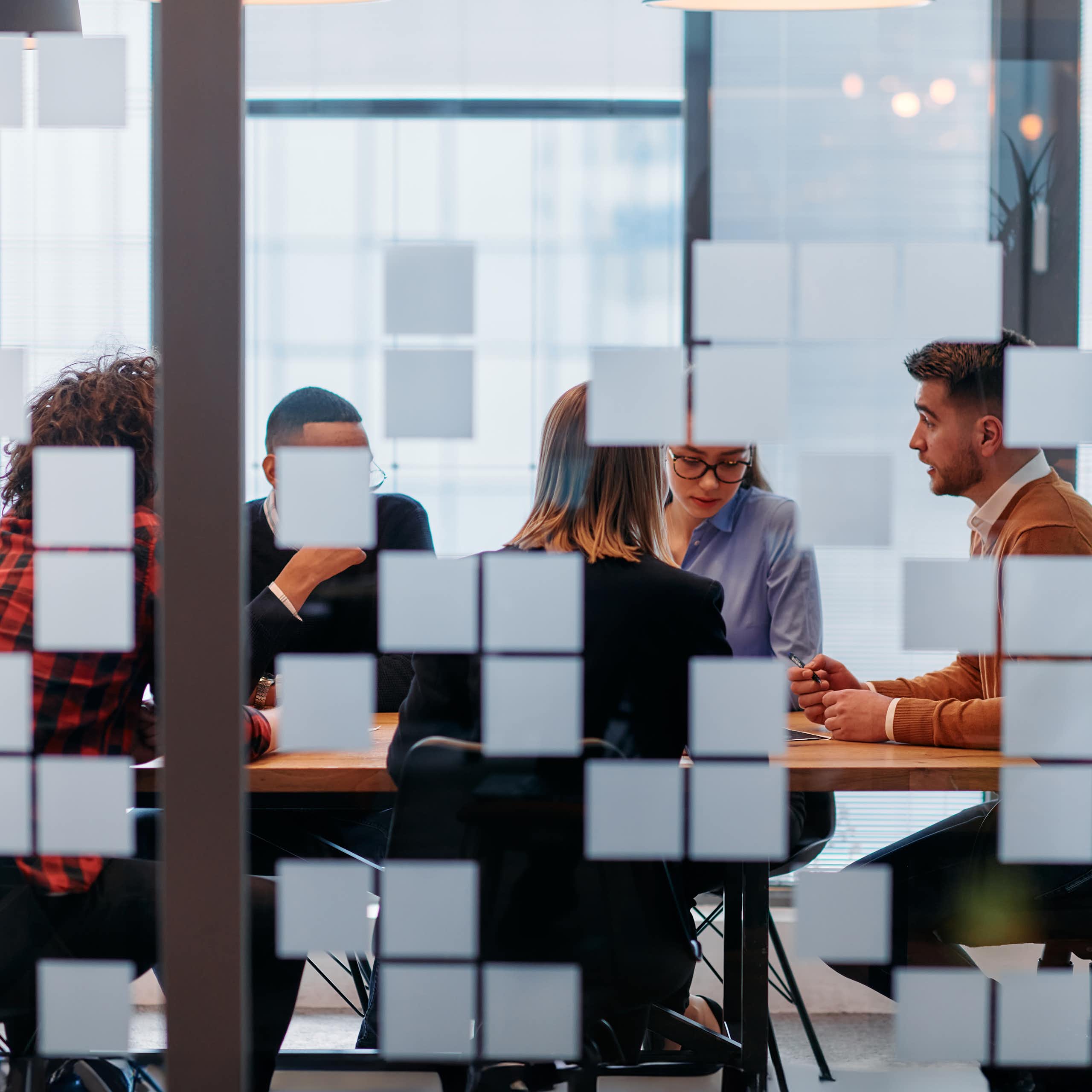 Employees are seen in a meeting room.