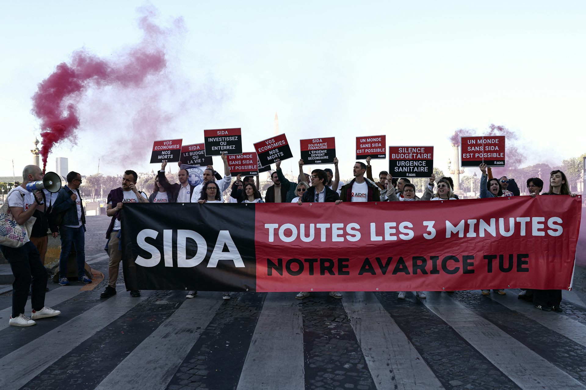 Des personnes manifestent à l’appel de l'association française AIDES, pour protester contre les coupes budgétaires décidées par l’administration américaine en matière notamment de lutte contre le VIH.