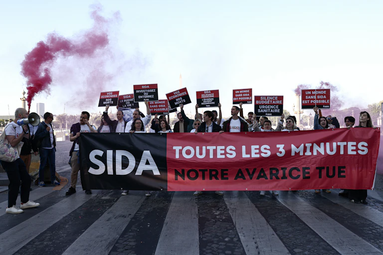 Des personnes manifestent à l’appel de l'association française AIDES, pour protester contre les coupes budgétaires décidées par l’administration américaine en matière notamment de lutte contre le VIH.
