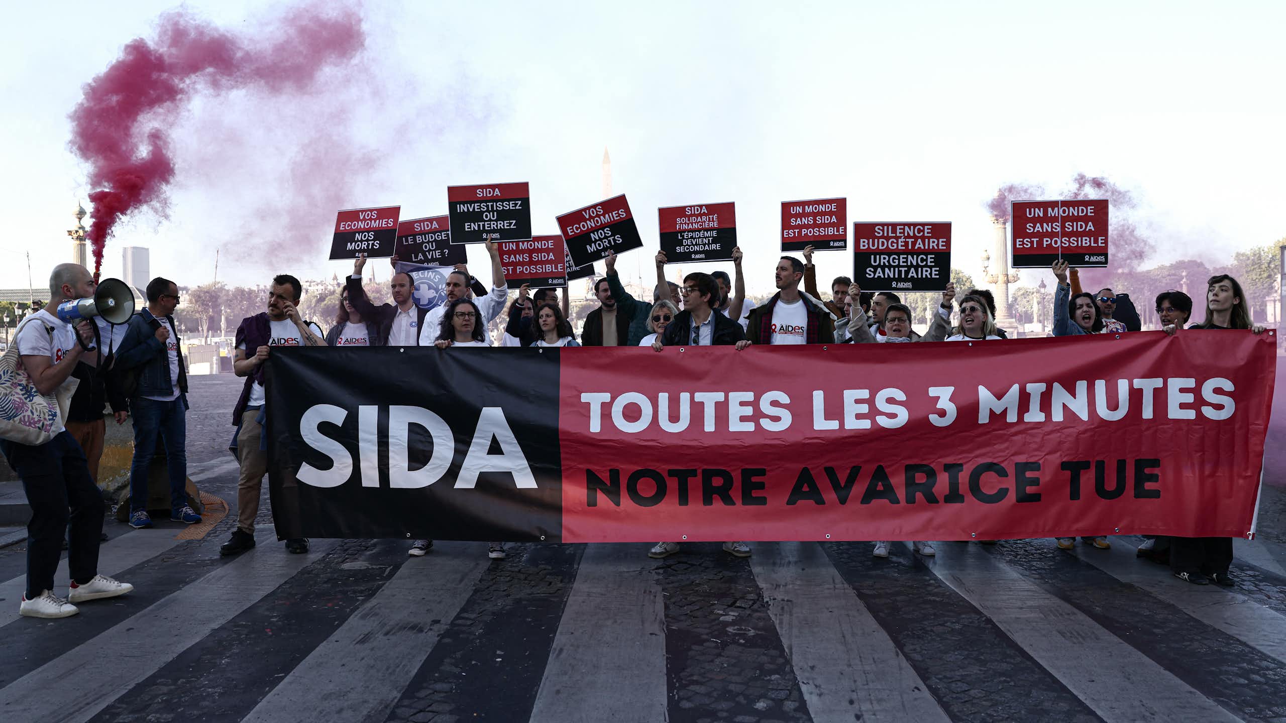 Des personnes manifestent à l’appel de l'association française AIDES, pour protester contre les coupes budgétaires décidées par l’administration américaine en matière notamment de lutte contre le VIH.