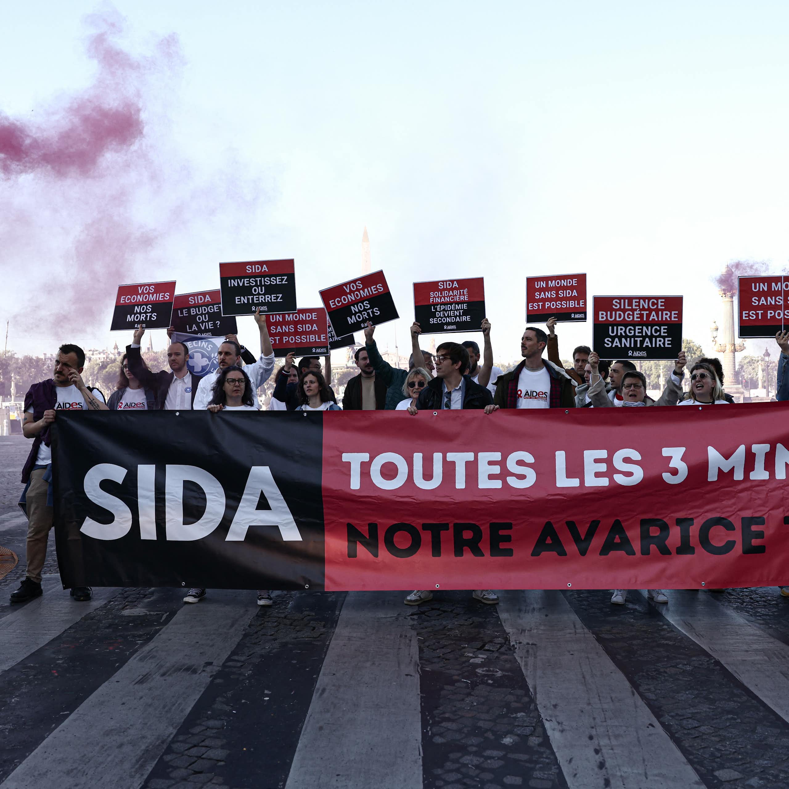 Des personnes manifestent à l’appel de l'association française AIDES, pour protester contre les coupes budgétaires décidées par l’administration américaine en matière notamment de lutte contre le VIH.