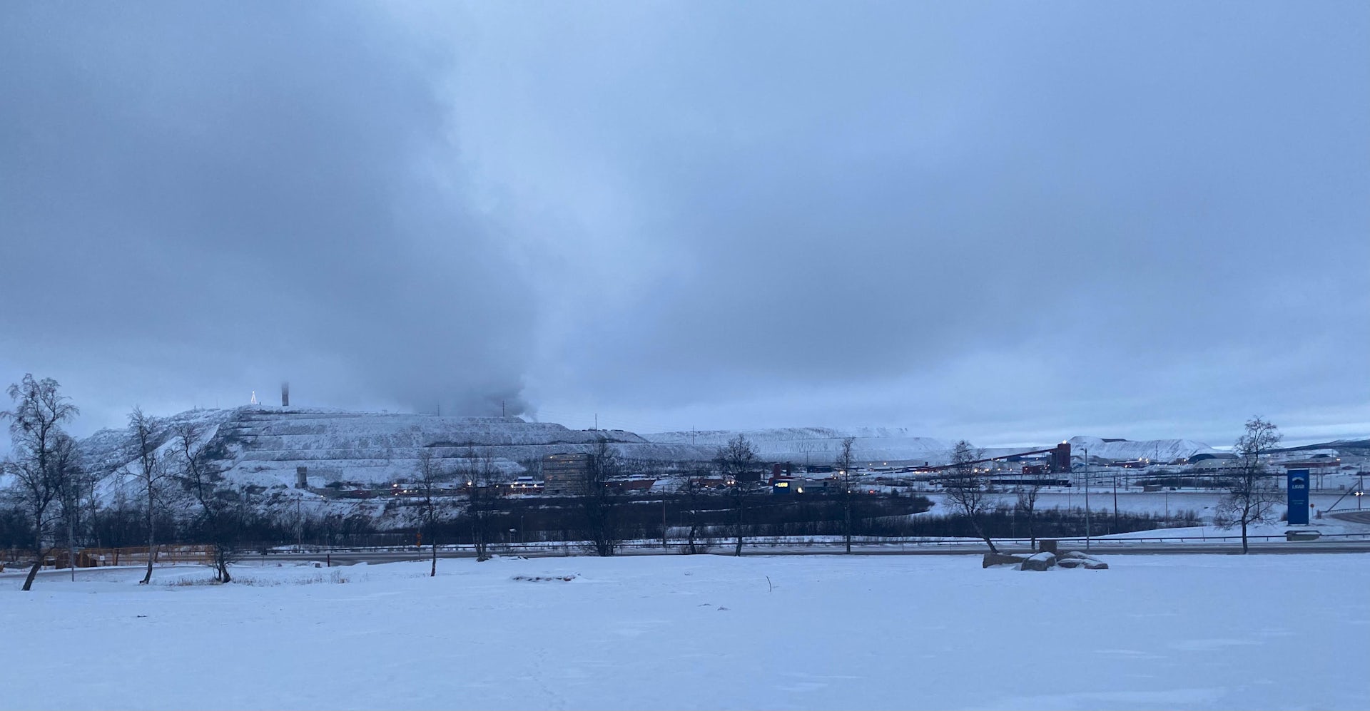 A landscape with snow and trees in the distance.