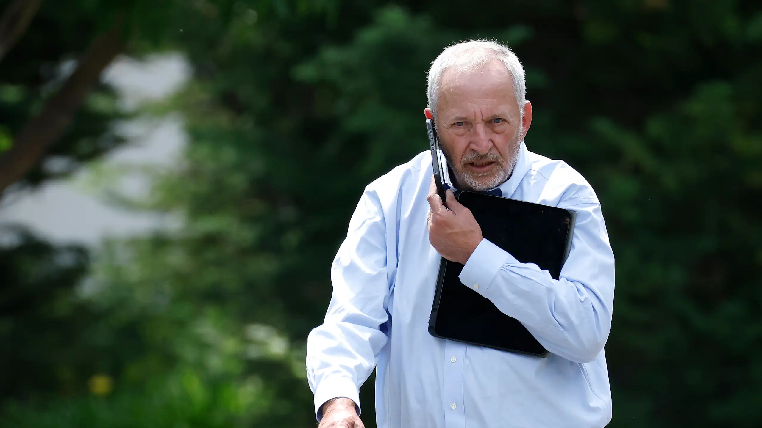 Larry Summers walks while talking into a mobile phone.