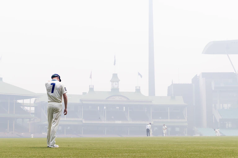 Liam Hatcher of the Blues can hardly be seen because of bushfire haze during a Sheffield Shield match at the SCG.