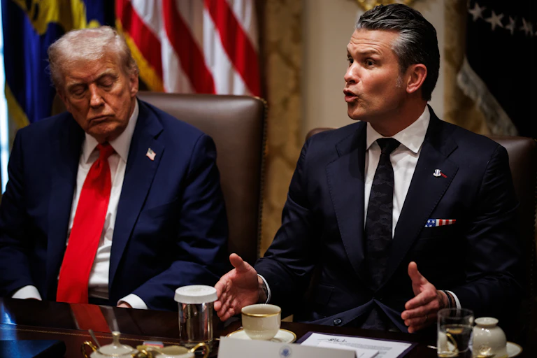 Donald Trump looks on as Pete Hegseth speaks during a White House meeting.