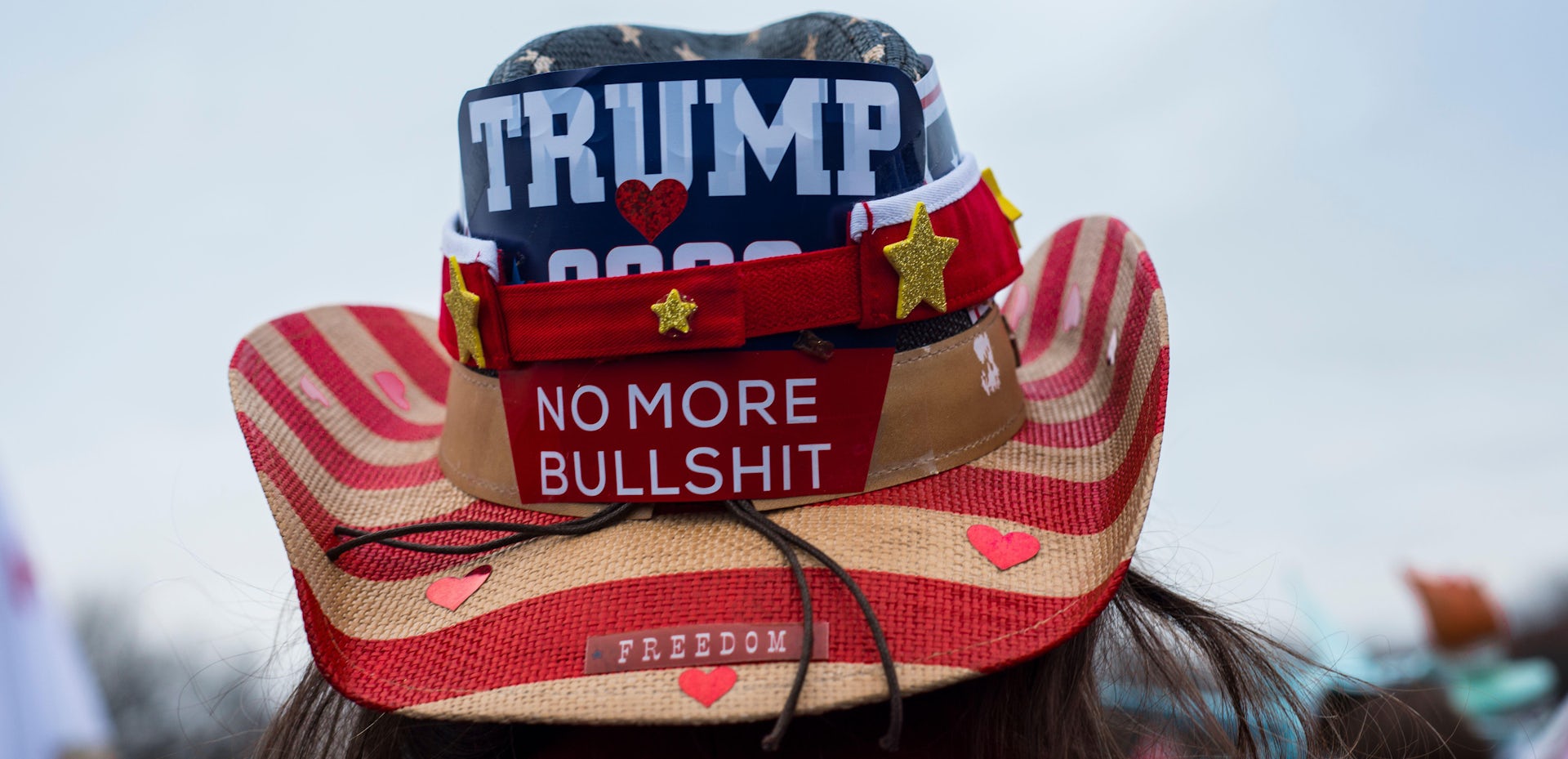 A Trump supporter wears a hat dclaring his views.