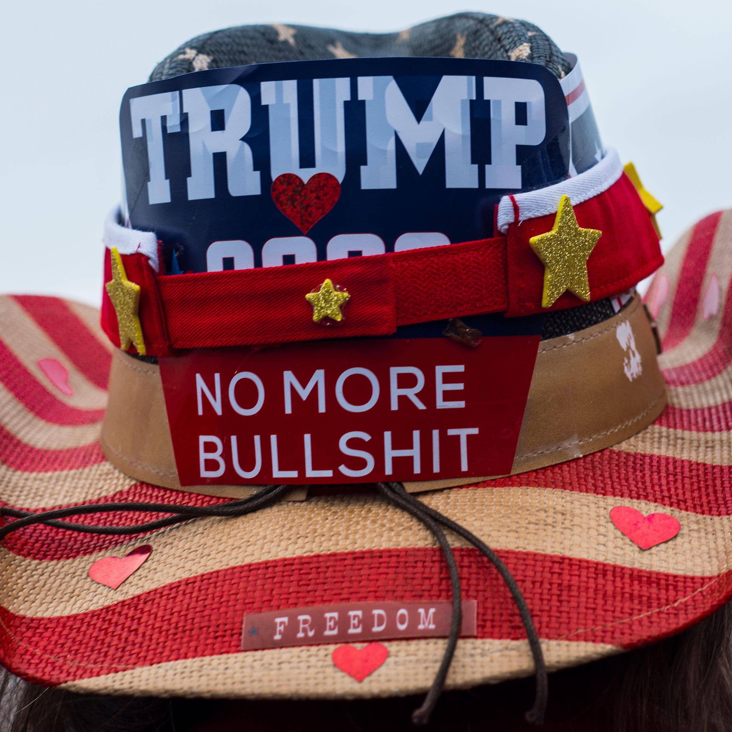 A Trump supporter wears a hat dclaring his views.