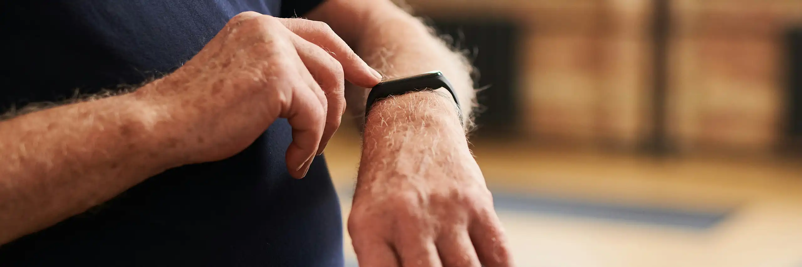 Une personne touchant une montre connectée à son poignet.