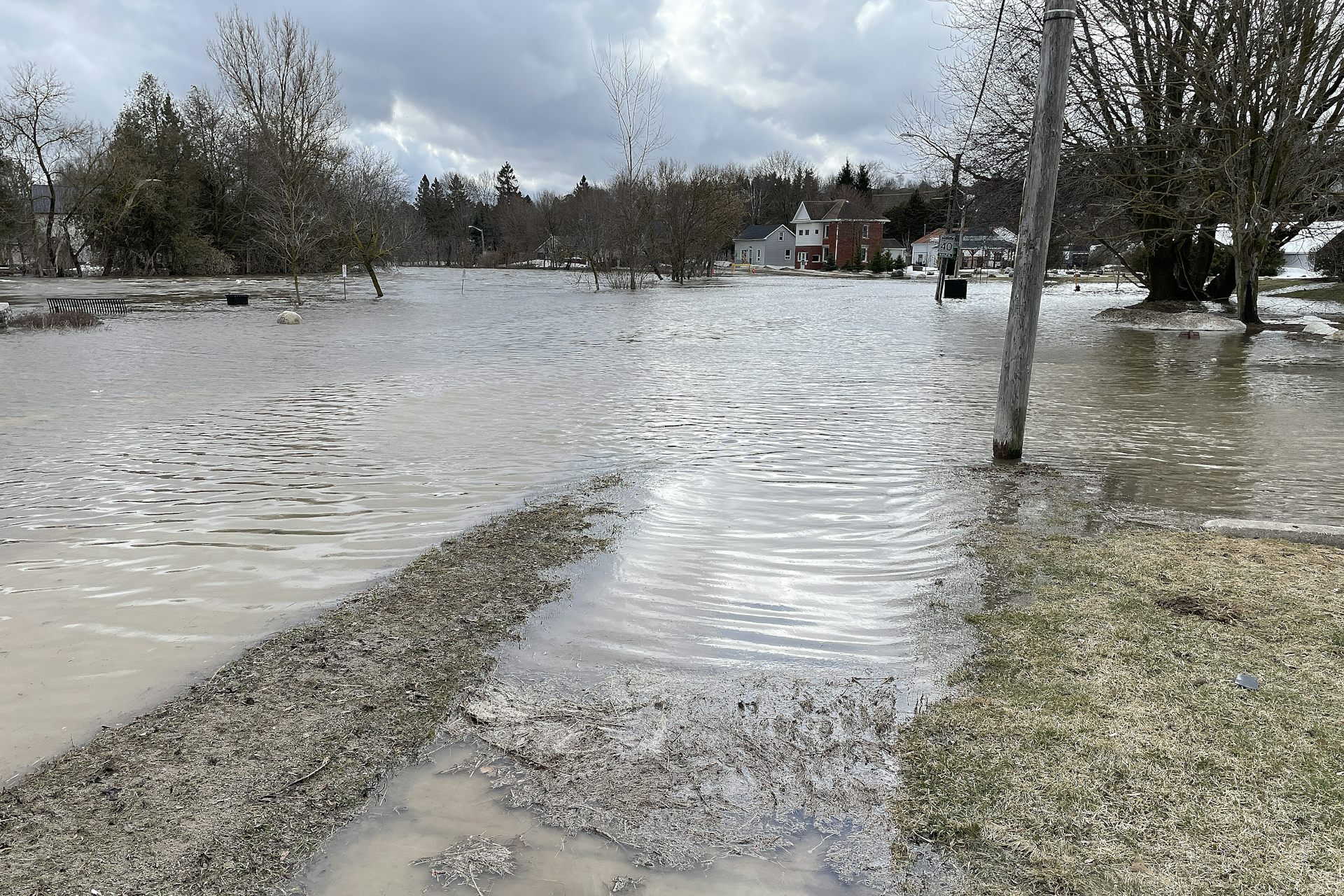 A town street underwater from a river that overflowed its banks.