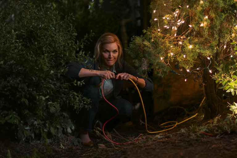 Michelle Pfeiffer unplugging Christmas tree lights.