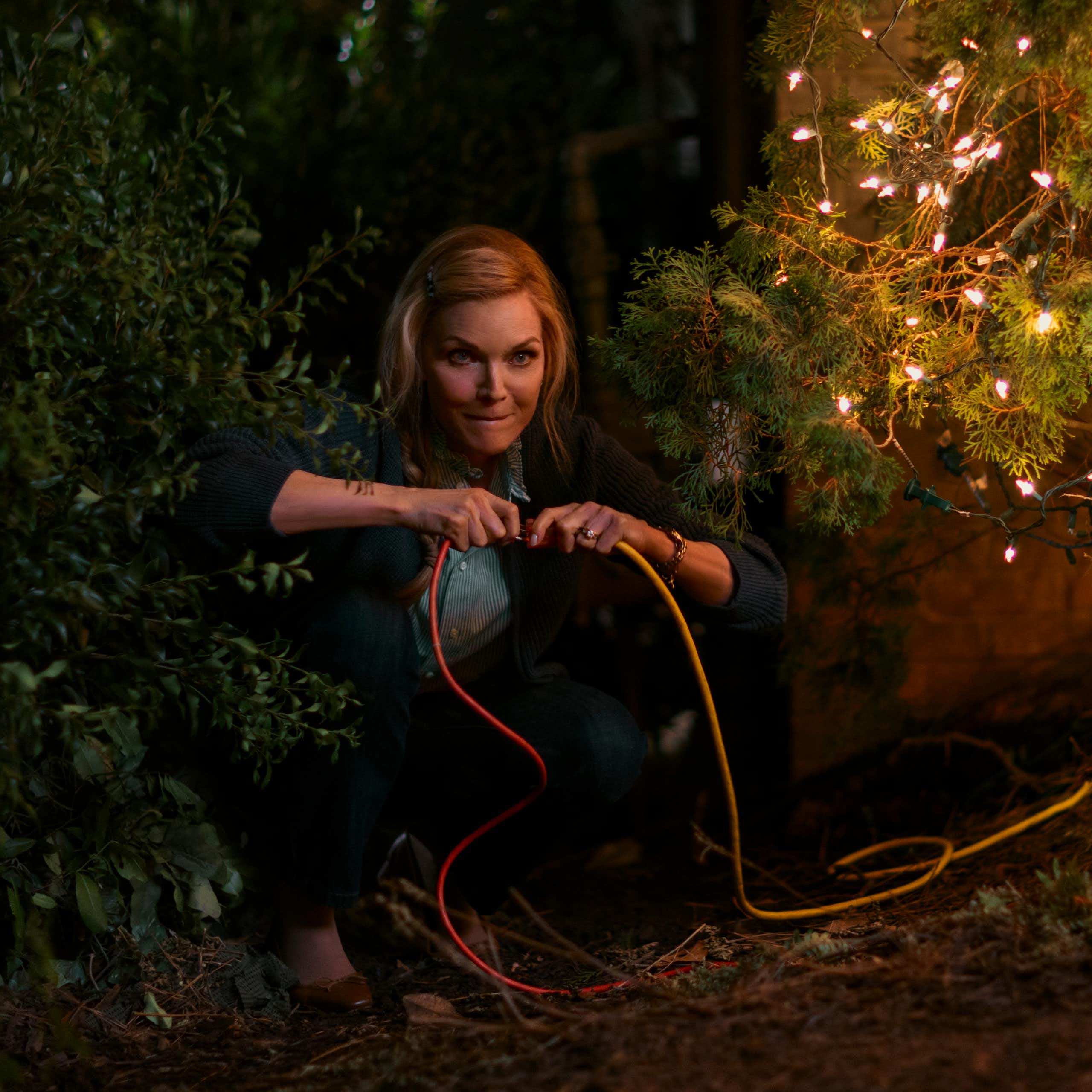 Michelle Pfeiffer unplugging Christmas tree lights.