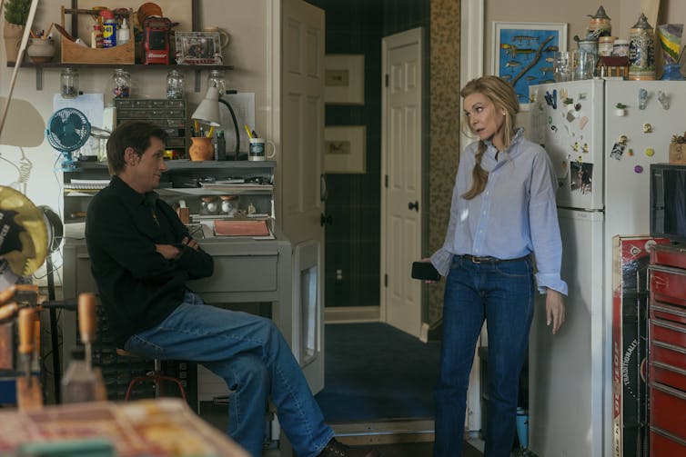 A husband and wife in a kitchen.