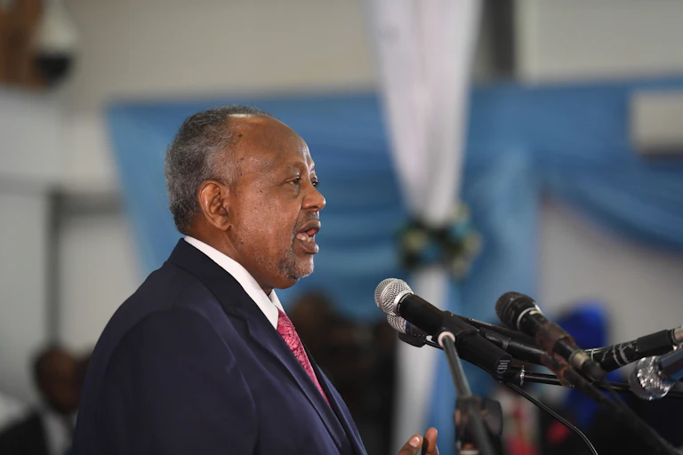 Man in suit and tie, speaking to a microphone