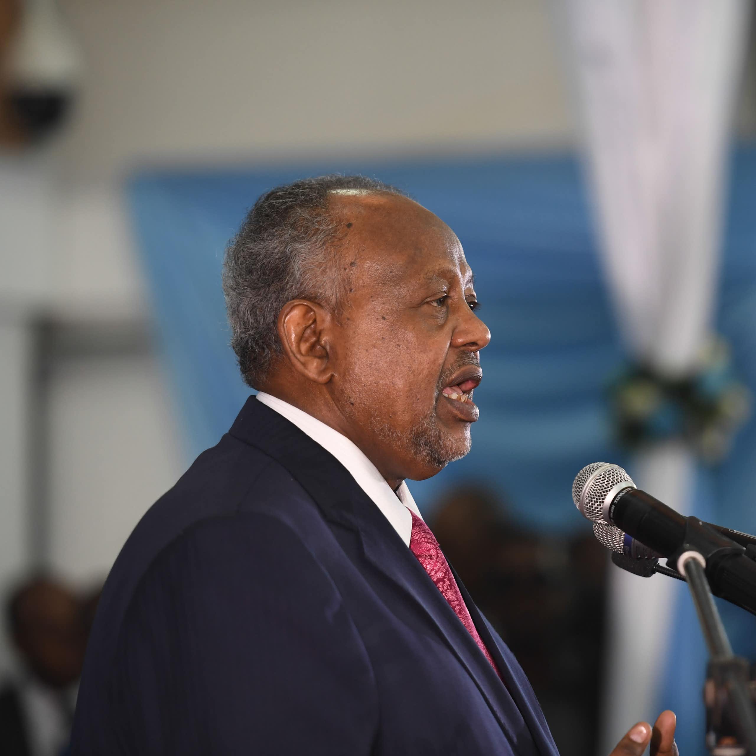 Man in suit and tie, speaking to a microphone