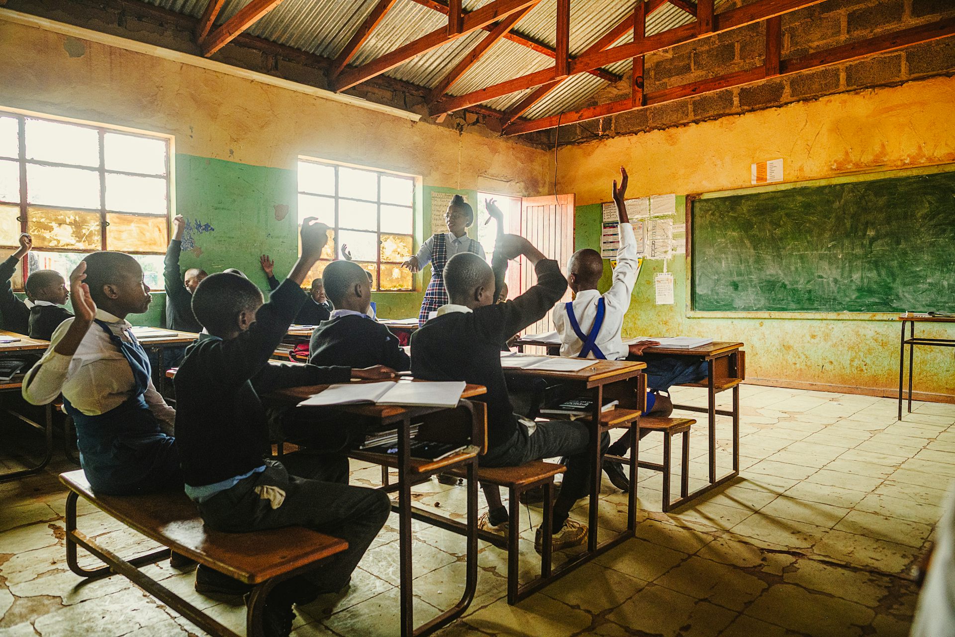 Classroom with children raising their hands