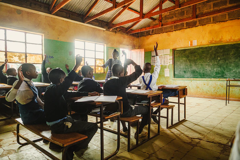 Classroom with children raising their hands