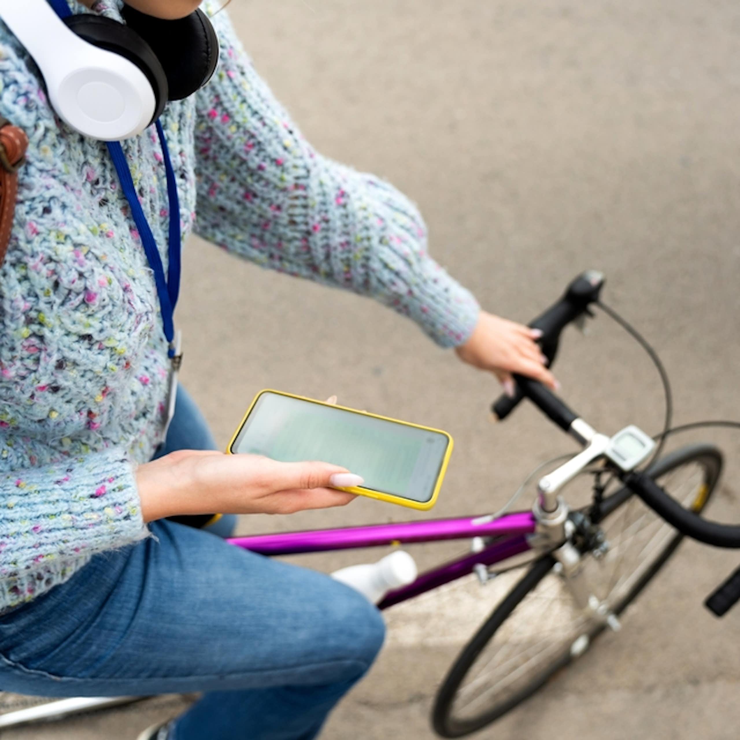 Étudiante avec un vélo et un smartphone.
