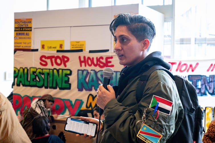 A poet wearing patches bearing the Palestine flag