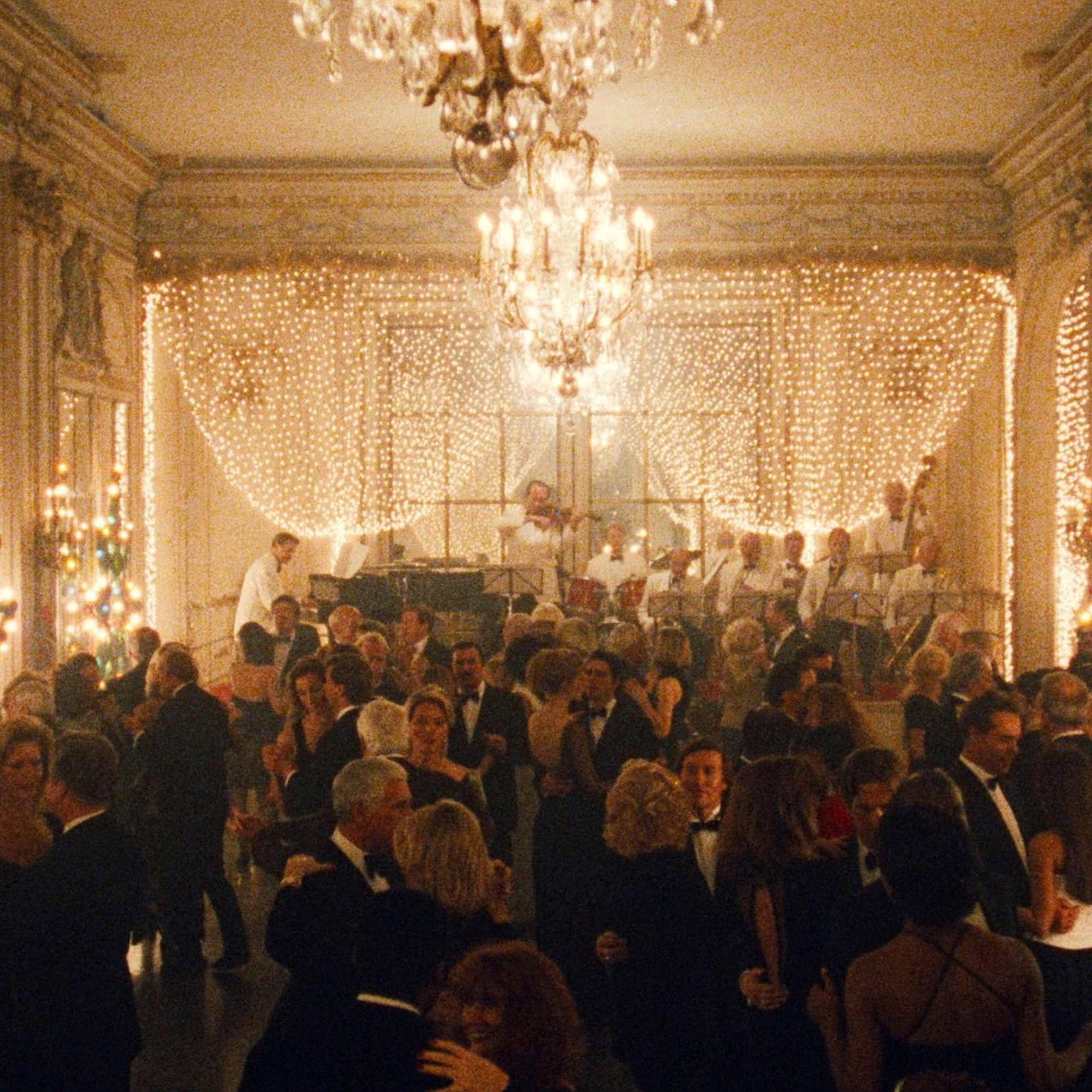 A large ballroom full of people decorated for Christmas with beautiful lighting.