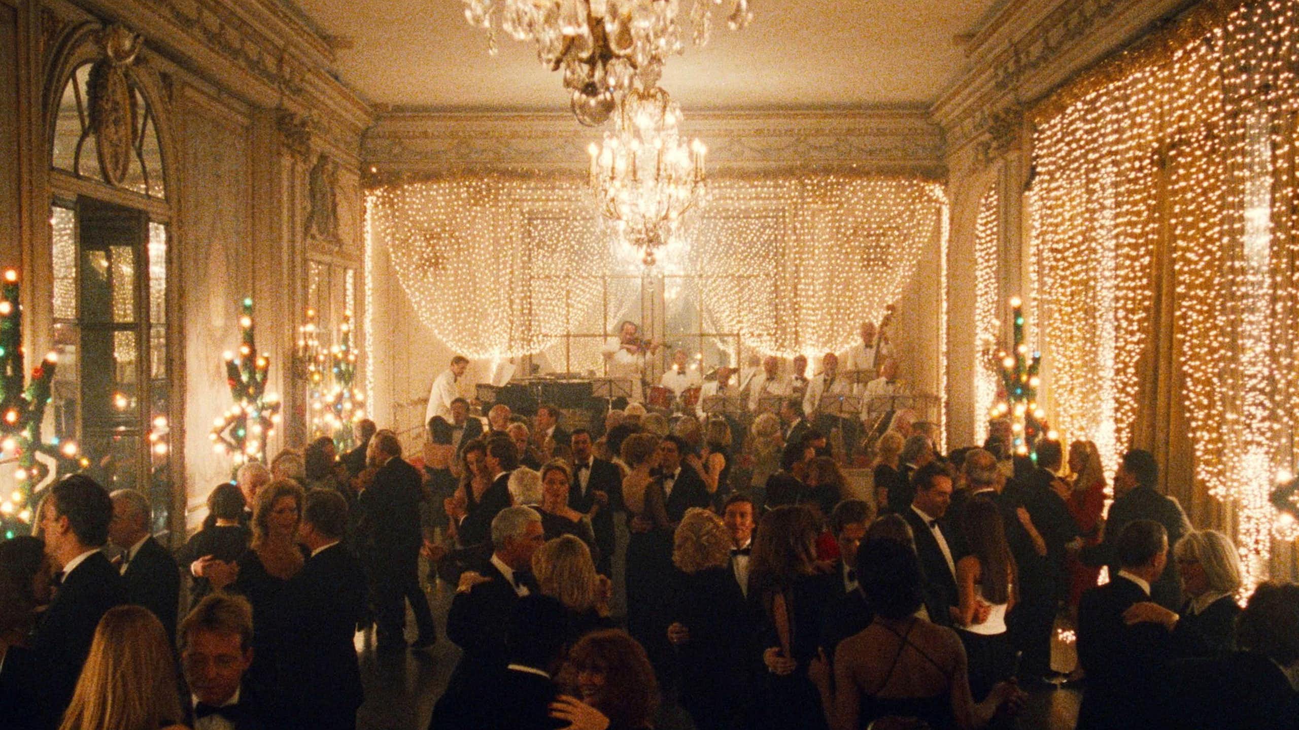 A large ballroom full of people decorated for Christmas with beautiful lighting.