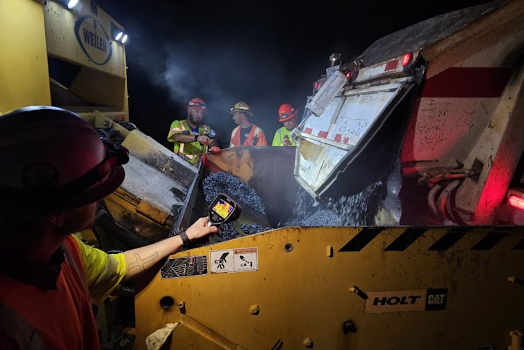 Heating asphalt in a large piece of construction equipment.