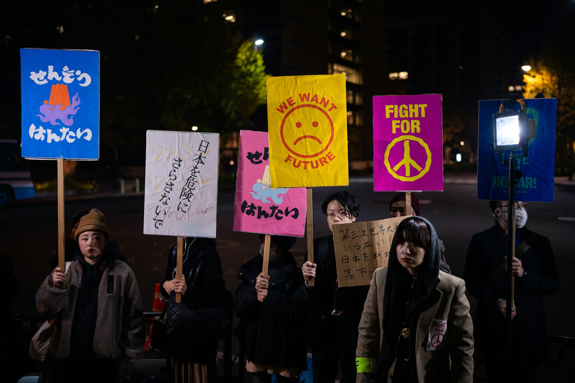 Protesters hold signs that read 'fight for peace' and 'we want a future.'