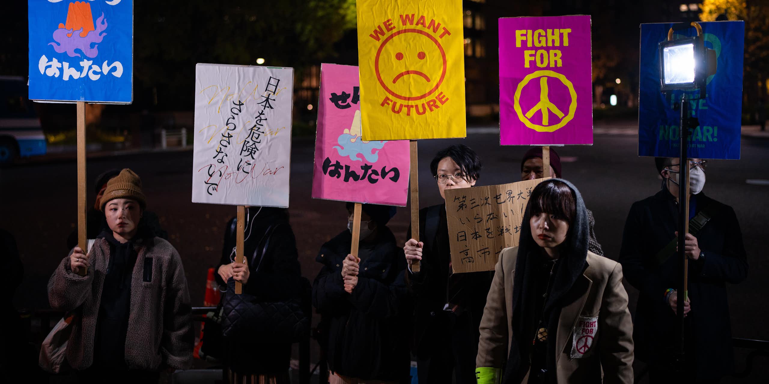 Protesters hold signs that read 'fight for peace' and 'we want a future.'