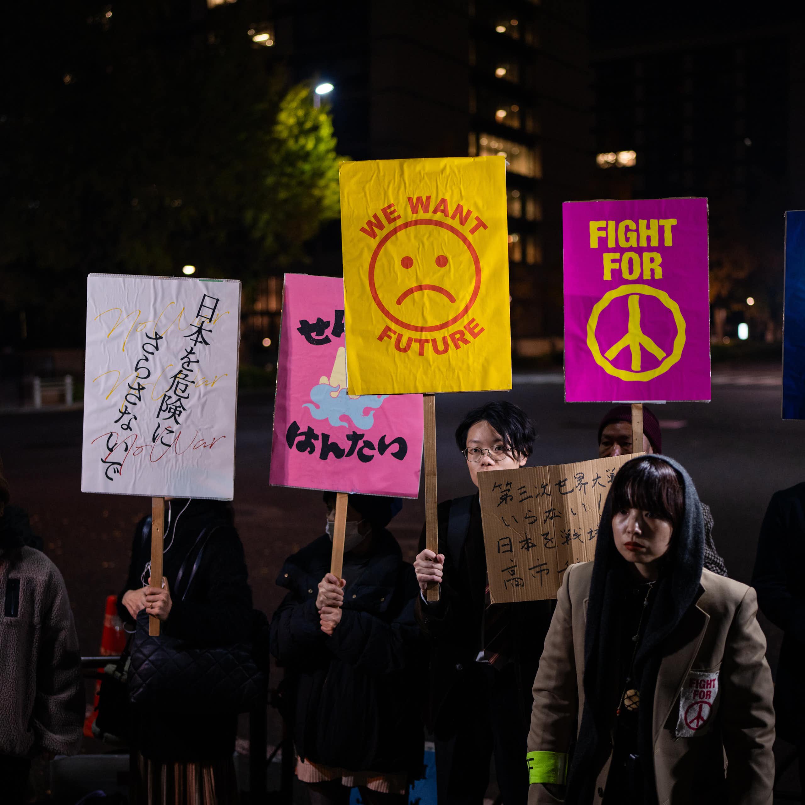 Protesters hold signs that read 'fight for peace' and 'we want a future.'