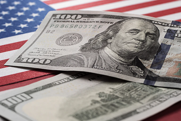 Dollar bills on top of a US flag.