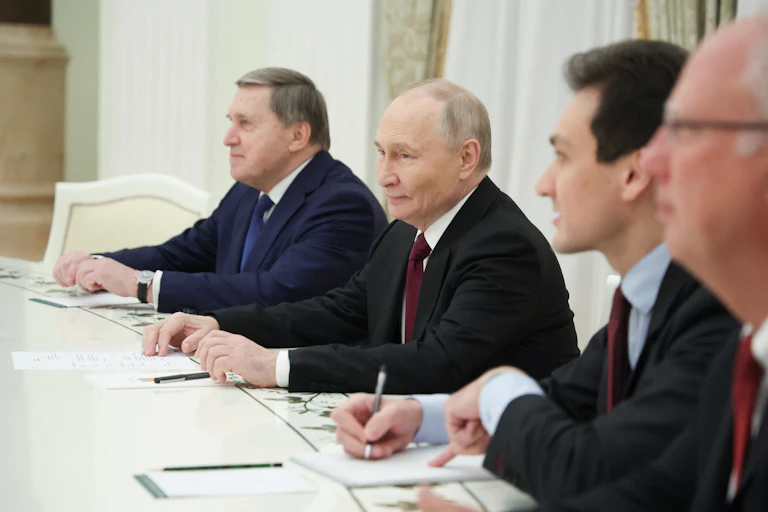 Men in suits sit at a table.